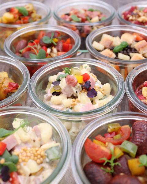 Vegetarische Speisen in Gläsern aufgetischt.