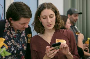Zwei Frauen schauen auf ein Handy Display und reden miteinander