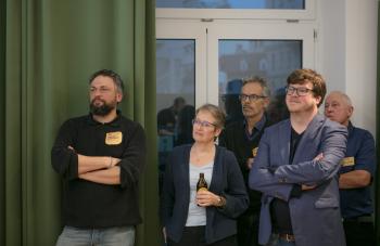 Fünf Personen aus dem Publikum schauen interessiert auf die Bühne