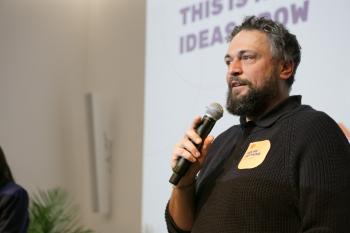 Martin Witter steht auf der Bühne uns spricht ins Mikrophone