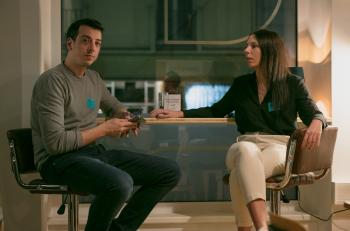 Eine Frau und ein Mann sitzen auf den Barhocker beim Fensterbrett und reden miteinander