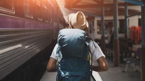 Rucksacktourist geht neben Zug